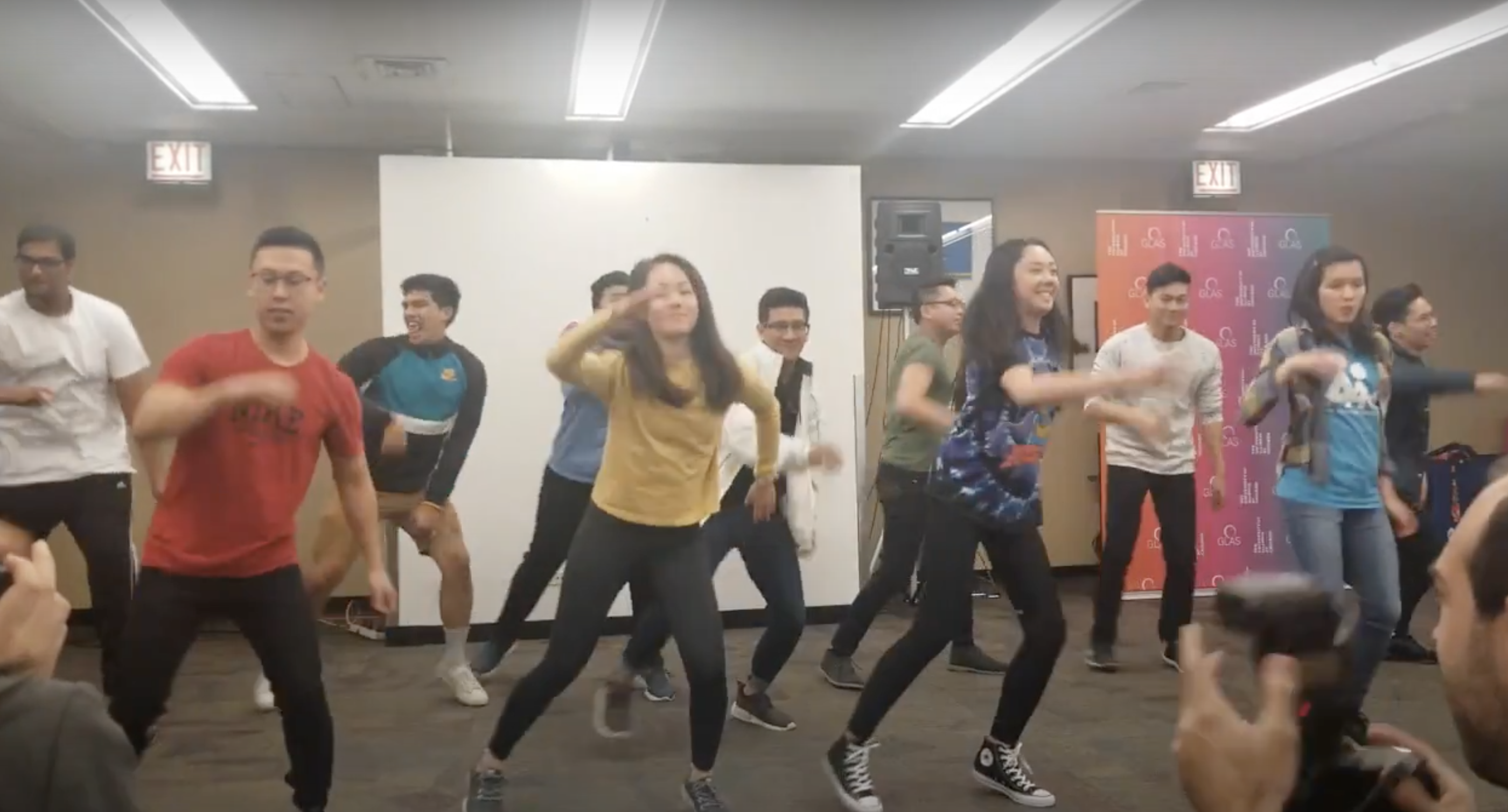 A group of many Asian American dancers performs